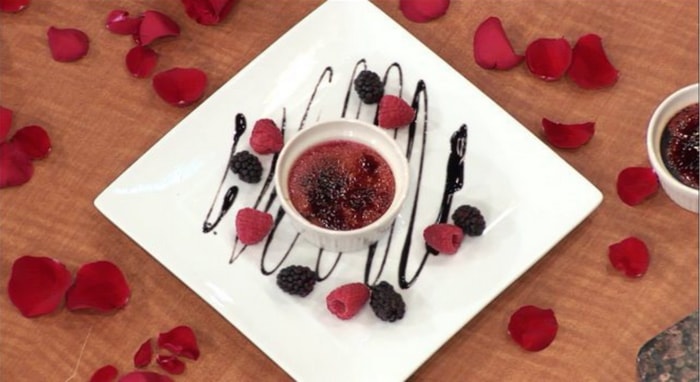 pink creme brulee plated with berries